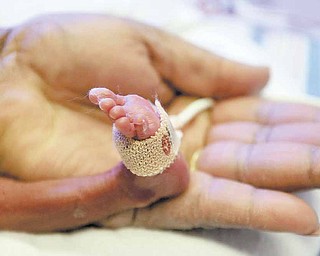 Nurse Rowena Lamont holds the foot of a three-day-old premature baby, born at 6 months, at St. Joseph's Regional Medical Center in Paterson, New Jersey.