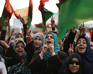 Libyan women, some holding pre-Gadhafi flags chant during a protest to demand the resignation of Libyan leader Moammar Gadhafi and the implementation of a no-fly zone, in Benghazi, eastern Libya, Thursday, March 10, 2011.