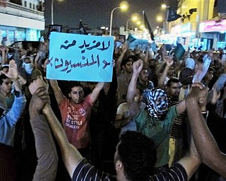 Saudi Shiite protesters chant slogans during a protest in Qatif, Saudi Arabia, Thursday, March 10, 2011. Saudi police have opened fire at a rally in the kingdom's east in an apparent escalation of efforts to stop planned protests.Government officials have warned they will take strong action if activists take to the streets after increasing calls for large protests around the oil-rich kingdom to press for democratic reforms. A witness in the eastern city of Qatif says gunfire and stun grenades were fired at several hundred protesters marching in the city streets Thursday. The witness, speaking on condition of anonymity because he feared government reprisal, said police in the area opened fire. The witness saw at least one protester injured. The small white signs in Arabic read: No more forgotten.".