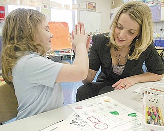 Jodi Kosek, a first-grade teacher at Harding Elementary, high-fives student Savana Cline. Kosek was named Youngstown City Schools’ Teacher of the Year in an award ceremony Monday morning.