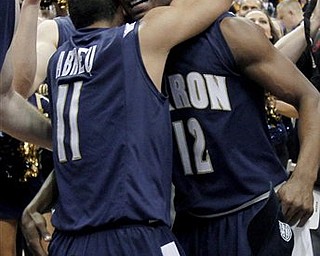Akron's Darryl Roberts (12) and Alex Abreu (11) hug after Akron won the NCAA college basketball Mid-American Conference championship 66-65 over Kent State in overtime Saturday, March 12, 2011, in Cleveland.