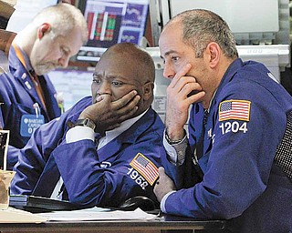 Specialists work at a post on the floor of the New York Stock Exchange Tuesday, March 15, 2011. Stocks have closed sharply lower Tuesday as the nuclear crisis in Japan weighed on global markets.