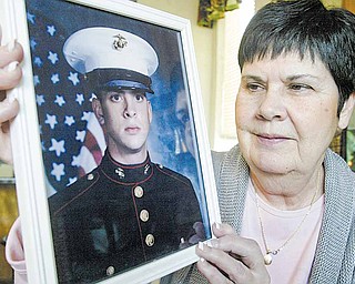 Winifred Flood holds a photograph of her son, Marine Sgt. Kenneth Flood. Winnie Flood didn’t get to say goodbye to her son in person when he was deployed last month to Afghanistan because the airline she booked to North Carolina wanted an extra $300 to change the date of her flight following her son’s change in deployment dates. Winifred Flood wants the airline to change its policies regarding military parents.