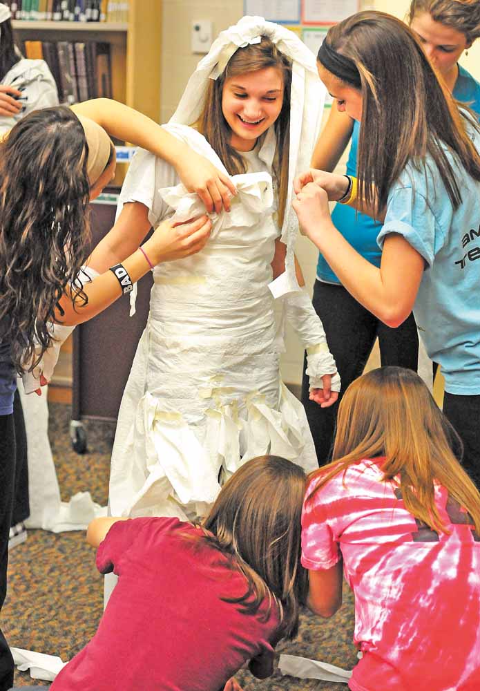 Jena Yambrovich gets a toilet paper wedding dress from her fellow South Range High School classmates at a Sisterhood Project event. The Sisterhood Project acts as a support group for freshman girls by integrating them with members of the senior class.