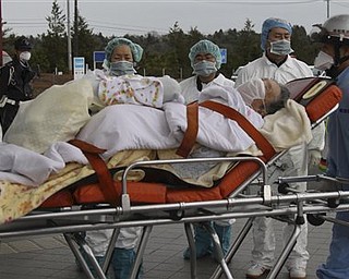An elderly person who lives in a house about 20 miles (30 kilometers) from the Fukushima Dai-ichi nuclear plant, is transferred to receive a medical check and will be transferred to a hospital later,  in the March 11 earthquake and tsunami-destroyed city of  Minamisoma, northern Japan Tuesday, March 22, 2011.  