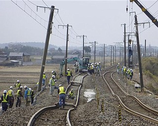 Workers repair the railway tracks damaged by the March 11 earthquake in Hitachinaka, Ibaraki Prefecture, Japan, Monday, March 21, 2011.