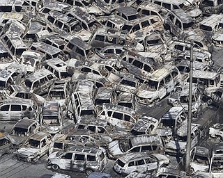 In this photo taken Friday, March 11, 2011, an aerial view shows vehicles washed away by an earthquake triggered tsunami in Hitachinaka, Ibaraki prefecture, Japan. The country's biggest recorded earthquake slammed into its eastern coast Friday. 