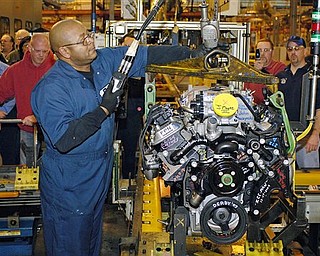 In this file photo taken Dec. 18, 2009, Willie Ray, an employee of GM, hoists the last big block V8 engine from the assembly line at the General Motors Powertrain plant in Tonawanda, N.Y. General Motors Co. is halting some production at its Buffalo, N.Y., engine plant because of a slowdown in parts from Japan. 