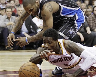 Orlando Magic's Jameer Nelson, top, and Cleveland Cavaliers' Manny Harris battle for a loose ball in the second quarter in an NBA basketball game, Monday, March 21, 2011, in Cleveland.