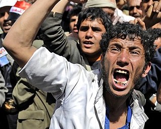 An anti-government protestor shouts slogans during a demonstration demanding the resignation of Yemeni President Ali Abdullah Saleh, in Sanaa,Yemen, Monday, March 21, 2011. Three Yemeni army commanders, including a top general, defected Monday to the opposition calling for an end to President Ali Abdullah Saleh's rule, as army tanks and armored vehicles deployed in support of thousands protesting in the capital. With the defection, it appeared Saleh's support was eroding from every power base in the nation - his own tribe called on him to step down, he fired his entire Cabinet ahead of what one government official said was a planned mass resignation, and his ambassador to the U.N. and human rights minister quit.