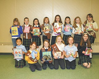 Outstanding collection: Girl Scout Troop 370 of Holy Family School, 2731 Center Road, Poland, sponsored a book drive, during which more than 500 gently used books were collected for children at the Warren G. Harding School in Youngstown. Displaying some of the books they rounded up during the drive are, in front, from left, Margaret Faur, Mya Blanco, Emily Testa, Mariah Farragher, Aubrianna McClellan and Audra Pesko, and, in back, Ally Marki, Josie Koback, Ashley Angiolelli, Kirtland Holovatick, Quinn Barton, Braiden Forsyth, Ashley Thompson and Mary Kate Kelty. Also participating in the drive was Alyssa Masternick, who is missing from the picture.