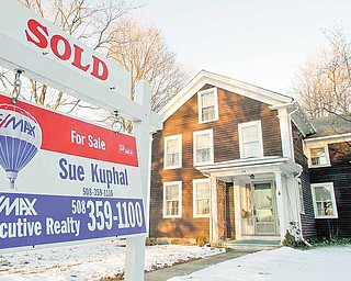 In this file photo taken Jan. 10, 2011, a sold sign is seen in front of a home, in Millis, Mass. New home? Or existing one? For buyers, the decision is getting easier. A wave of foreclosures has sent prices of previously occupied homes sinking. New-home prices have fallen much less.