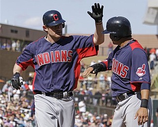 Cleveland Indians' Austin Kearns, left, is greeted by teammate Shin-Soo Choo, right, after hitting a two-run home run of Arizona Diamondbacks relief pitcher Carlos Rosa during the sixth inning of their spring training baseball game at Salt River Fields at Talking Stick near Scottsdale, Ariz., Tuesday, March 22, 2011. 