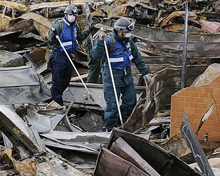 Japan Air Self-Defense Force's members search for missing persons through debris in the March 11 earthquake and tsunami-destroyed town of Yamada, northern Japan Wednesday, March 23, 2011.