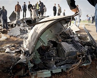 Libyans inspect the wreckage of a US  F15 fighter jet after it crashed in an open field in the village of  Bu Mariem, east of Benghazi, eastern Libya, Tuesday, March 22, 2011, with both crew ejecting safely. The U.S. Africa Command said both crew members were safe after what was believed to be a mechanical failure of the Air Force F-15. The aircraft, based out of Royal Air Force Lakenheath, England, was flying out of Italy's Aviano Air Base in support of Operation Odyssey Dawn.