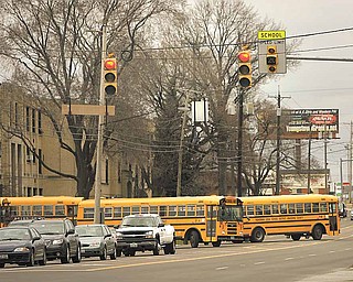Buses leave the Boardman Center Middle School parking lot on Market Street on Tuesday afternoon into the recently installed school zone. The flashing school zone lights are being re-programmed to account for daylight-saving time.