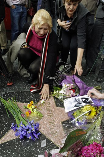 A woman reaches down to touch Elizabeth Taylor's star on the Hollywood Walk of Fame in Los Angeles Wednesday, March 23, 2011. Taylor died early Wednesday of congestive heart failure at the age of 79.  