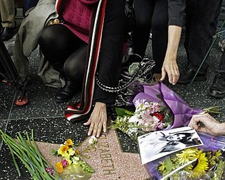 A woman reaches down to touch Elizabeth Taylor's star on the Hollywood Walk of Fame in Los Angeles Wednesday, March 23, 2011. Taylor died early Wednesday of congestive heart failure at the age of 79.
