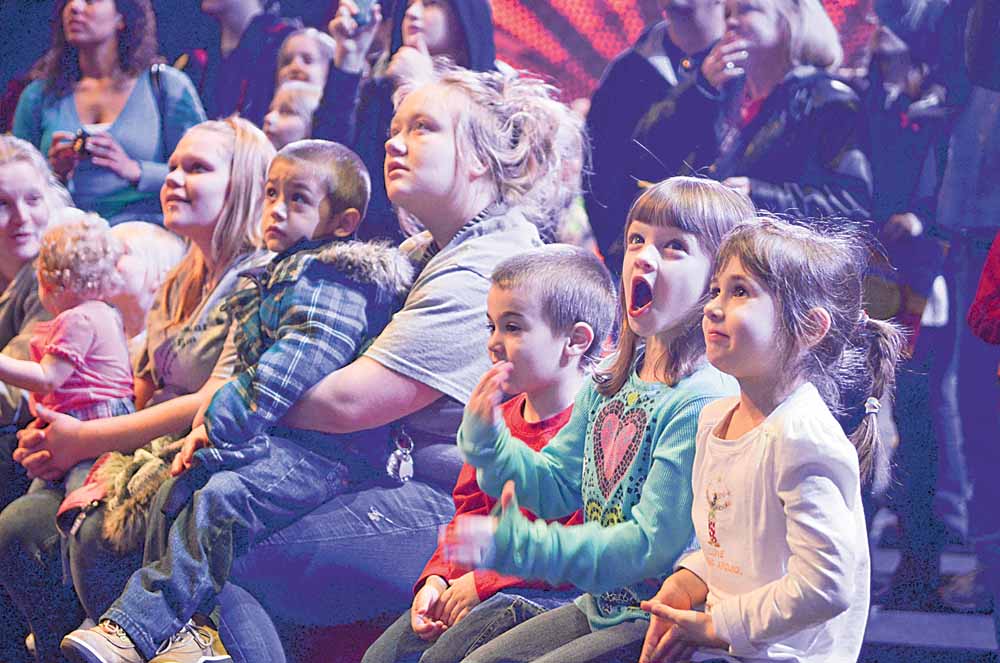 Travis Mills (red), 4, of Canfield, Caiden Smith (blue), 6, of Austintown, and DeeAnna Mills (white), 6, of Canfield, watch a pre-show perfomance Friday night at the Covelli Center.
