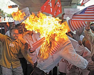 Activists of Communist Party of India burn an effigy of the United States as they protest against the military attack on Libya by the U.S., in Hyderabad, India, Friday, March 25, 2011. NATO's military staff is drawing up detailed plans to assume full control of the no-fly zone over Libya in coming days, after member nations agreed to take on the operation from a U.S.-led coalition. 