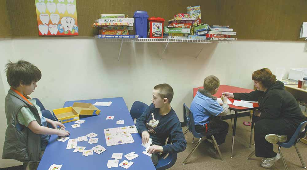 Tammy Chumley, far right, a teacher at the Rich Center for Autism at Youngstown State University, works with students at the center. The center is located on the first floor of Fedor Hall at YSU. With 70 students and 35 staff members, the center is contemplating a move to larger quarters.