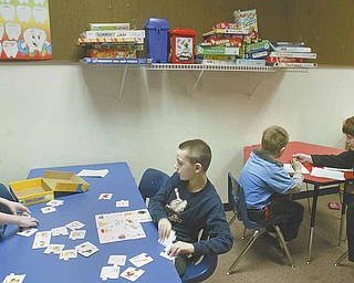Tammy Chumley, far right, a teacher at the Rich Center for Autism at Youngstown State University, works with students at the center. The center is located on the first floor of Fedor Hall at YSU. With 70 students and 35 staff members, the center is contemplating a move to larger quarters.