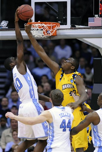 Marquette Chris Otule (42) reaches through the basket to block a shot by North Carolina's Harrison Barnes (40) during the second half of an an East regional semifinal game in the NCAA college basketball tournament Friday, March 25, 2011, in Newark, N.J. 