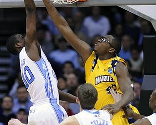 Marquette Chris Otule (42) reaches through the basket to block a shot by North Carolina's Harrison Barnes (40) during the second half of an an East regional semifinal game in the NCAA college basketball tournament Friday, March 25, 2011, in Newark, N.J. 