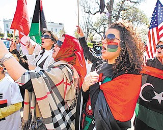 Mariam Jamal Ismail, front right, and Randa Elzouzary, center, both from Libya, join protestors in front of the White House in Washington, Saturday, March 26, 2011, condemning Libyan strongman Moammar Gadhafi and in support for the U.N. Security Council Resolution 1973, approving a No-Fly Zone over Libya and authorizing all necessary measures to protect civilians.