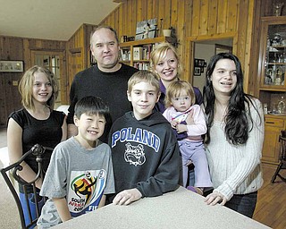 Sean Hiramatsu, 10, of Tokyo enjoys spending time with his host family in Poland. With him at right is Brendan
McBride, 13; and, back row from left, Madeleine McBride, 11; David Simonelli, Michele Simonelli, Syliva Simonelli, 17 months; and Bridgette McBride, 15. He began attending classes in Poland last week. His family in Japan believed Poland would serve as a haven from the aftermath of the recent earthquake.