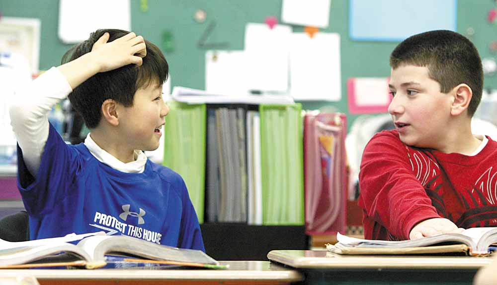 Sean Hiramatsu, 10, of Japan interacts with a classmate at McKinley Elementary School in Poland. Sean’s parents sent him to the Mahoning Valley after the earthquake and tsunami in Japan earlier this month. With Sean in math class is fellow fifth- grader Mark Pompeo.
