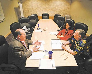 Financial planner Patrick Dougherty, left, works with Luchia and William Kingsley, right, in his Plano, Texas office, February 22, 2011.
