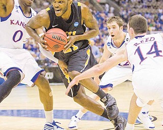 Kansas forward Thomas Robinson (0), Kansas guard Brady Morningstar (12) and Kansas guard Tyrel Reed (14) tried to slow VCU forward Jamie Skeen (21) as he drove toward the basket during first-half action. The University of Kansas faced Virginia Commonwealth University in the Southwest Regional Final of the men's NCAA Division I Basketball Championships at the Alamodome on Sunday, March 27, 2011, in San Antonio, Texas.