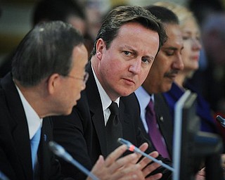 British Prime Minister David Cameron, centre,   listens to UN Secretary General Ban Ki-Moon, left,  speak at the opening of the Libya Conference in London Tuesday March 29, 2011.  International leaders plotted out an endgame Tuesday for Moammar Gadhafi's tottering regime, as British Prime Minister David Cameron accused the Libyan leader of shooting and starving his opponents into submission. 