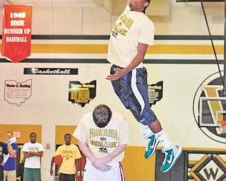 Ursuline’s Khiree Gregory soars over Mooney’s Danny Reese during the second round of a dunk contest at the
Frank Bubba Memorial Classic on Wednesday at Warren Harding High School.