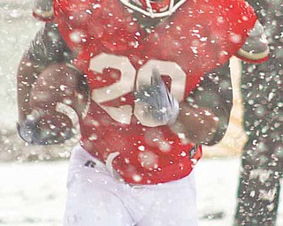 Youngstown State sophomore tailback Allen Jones runs a drill during Wednesday’s practice at Stambaugh Stadium, where a snow shower made it look and feel more like winter than spring.