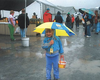 Grace Katherine Paulin, daughter of Bethany Paulin of New Middletown, doesn't let the rain dampen her spirits at the Rogers Flea Market. Photo submitted by Bethany Paulin.