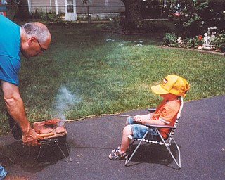 Cooper Wilson, 5, cooks with his "Papa," James Cardelein, as they get ready for a Memorial Day picnic. The photo, from 2010, was submitted by Cooper's great-grandma, Irene Cardelein of Youngstown.