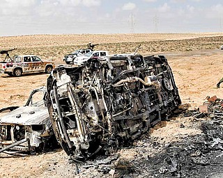 A Libyan rebel walks past the charred remains of the vehicles, belonging to the Libyan rebels, which were allegedly targeted killed in NATO coalition airstrike overnight at the front line near Brega, Libya, Saturday, April 2, 2011. NATO said on Saturday that it was investigating Libyan rebel reports that a coalition warplane had struck a rebel position that was firing into the air near the eastern front line of the battle with Gadhafi's forces.