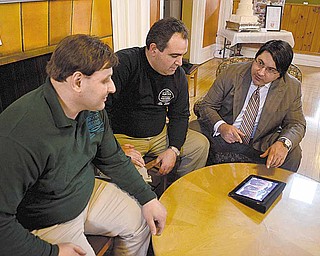 Michael Capito, right, gives a presentation on the benefits of using an iPad in business to Nick Liakaris, left, and Bill Axiotis, both of Warren and owners of The Mocha House.