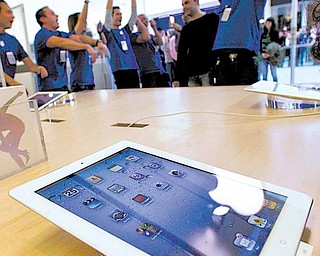 Staff cheer one of the first customers to enter the Apple store as the European launch of the iPad 2 went on sale in Madrid Friday, March 25, 2011. The iPad 2 is the updated version of Apple Inc.'s iPad tablet computer.