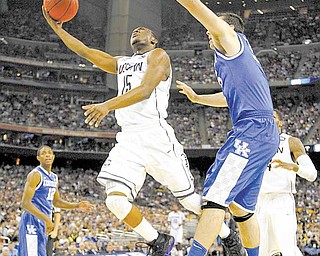 Connecticut guard Kemba Walker (15) goes up against Kentucky forward Josh Harrellson (55) during first-half action in the men's NCAA Final Four semifinals at Reliant Stadium in Houston, Texas, Saturday, April 2, 2011.