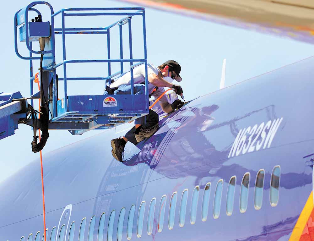 A member of the National Transportation and Safety Board investigating the emergency landing of Southwest Airlines flight 812 cuts away a portion of the planes fuselage on Sunday, April 3, 2011 in Yuma, Ariz.  Federal records show cracks were found and repaired a year ago in the frame of the Southwest Airlines Boeing 737-300 that made an emergency landing at an Arizona military base after a hole was torn from the passenger cabin. No one was seriously injured Friday as the aircraft carrying 118 people rapidly lost cabin pressure and made a controlled descent from 34,500 feet, landing safely near Yuma, Ariz., 150 miles southwest of Phoenix. 