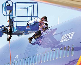 A member of the National Transportation and Safety Board investigating the emergency landing of Southwest Airlines flight 812 cuts away a portion of the planes fuselage on Sunday, April 3, 2011 in Yuma, Ariz. Federal records show cracks were found and repaired a year ago in the frame of the Southwest Airlines Boeing 737-300 that made an emergency landing at an Arizona military base after a hole was torn from the passenger cabin. No one was seriously injured Friday as the aircraft carrying 118 people rapidly lost cabin pressure and made a controlled descent from 34,500 feet, landing safely near Yuma, Ariz., 150 miles southwest of Phoenix.