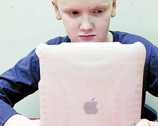 Chris Blair, a student at the Rich Center for Autism at Youngstown State University, uses an iPad. The devices help children with the disorder with language and other skills.