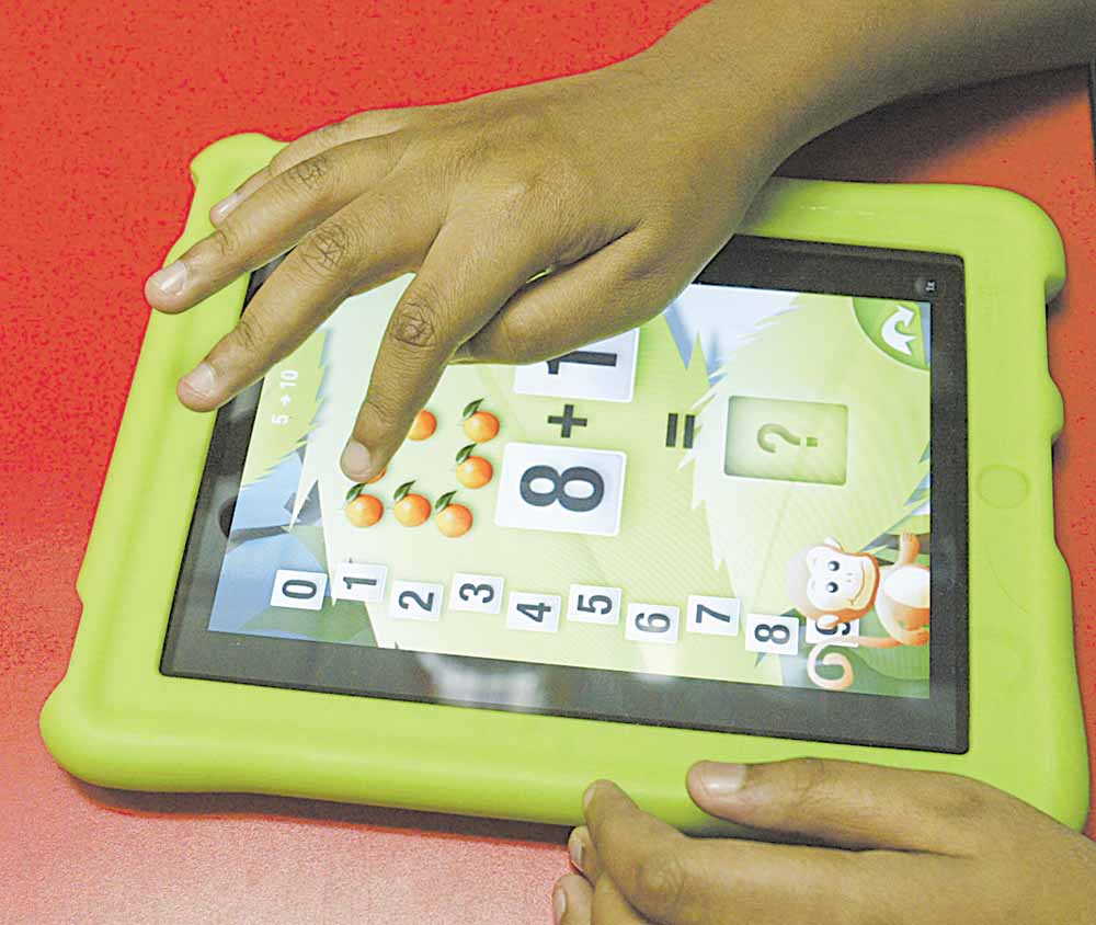 A student at the Rich Center for Autism at Youngstown State University uses an iPad application that teaches math.