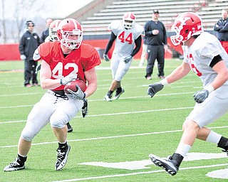 Youngstown State tight end Nate Adams (42) tries to elude strong safety Gannon Hulea (16) during the Penguins’ fi rst spring scrimmage Saturday at YSU’s Stambaugh Stadium.