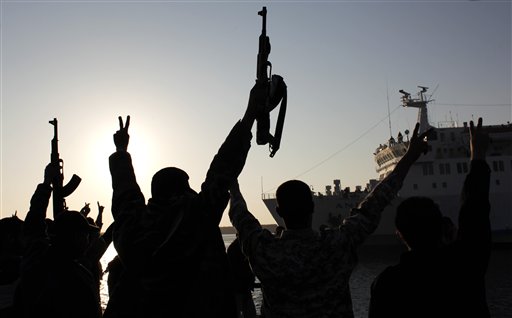 Libyan rebels chant slogans, flash "V" signs and wave  guns during a welcome reception for fellow injured Libyans on board the Turkish ship Ankara, carrying 250 wounded from Misrata, as it enters the port of Benghazi, Libya Sunday, April 3, 2011. Libyan rebels want to install a parliamentary democracy in place of longtime ruler Moammar Gadhafi, one of their top leaders said Sunday, dismissing Western fears that their movement could be hijacked by Islamic extremists. (AP Photo/Nasser Nasser)