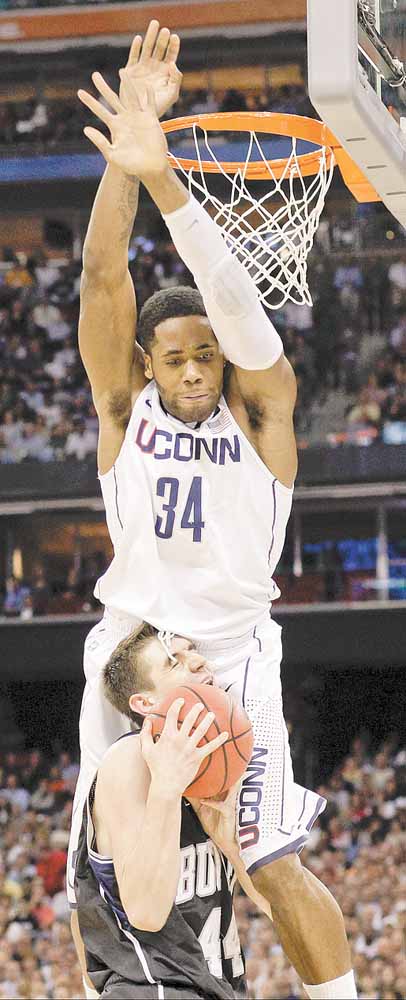 Connecticut's Alex Oriakhi topples over  Butler's Andrew Smith during the first half of the men's NCAA Final Four college basketball championship game Monday, April 4, 2011, in Houston. 