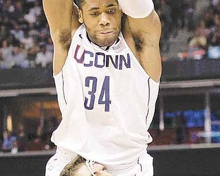 Connecticut's Alex Oriakhi topples over Butler's Andrew Smith during the first half of the men's NCAA Final Four college basketball championship game Monday, April 4, 2011, in Houston.